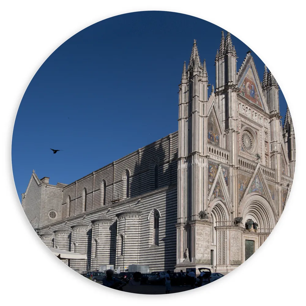 Dibond Muurcirkel - Zijaanzicht van Vogel boven Kathedraal van Orvieto onder Blauwe Lucht in Italië