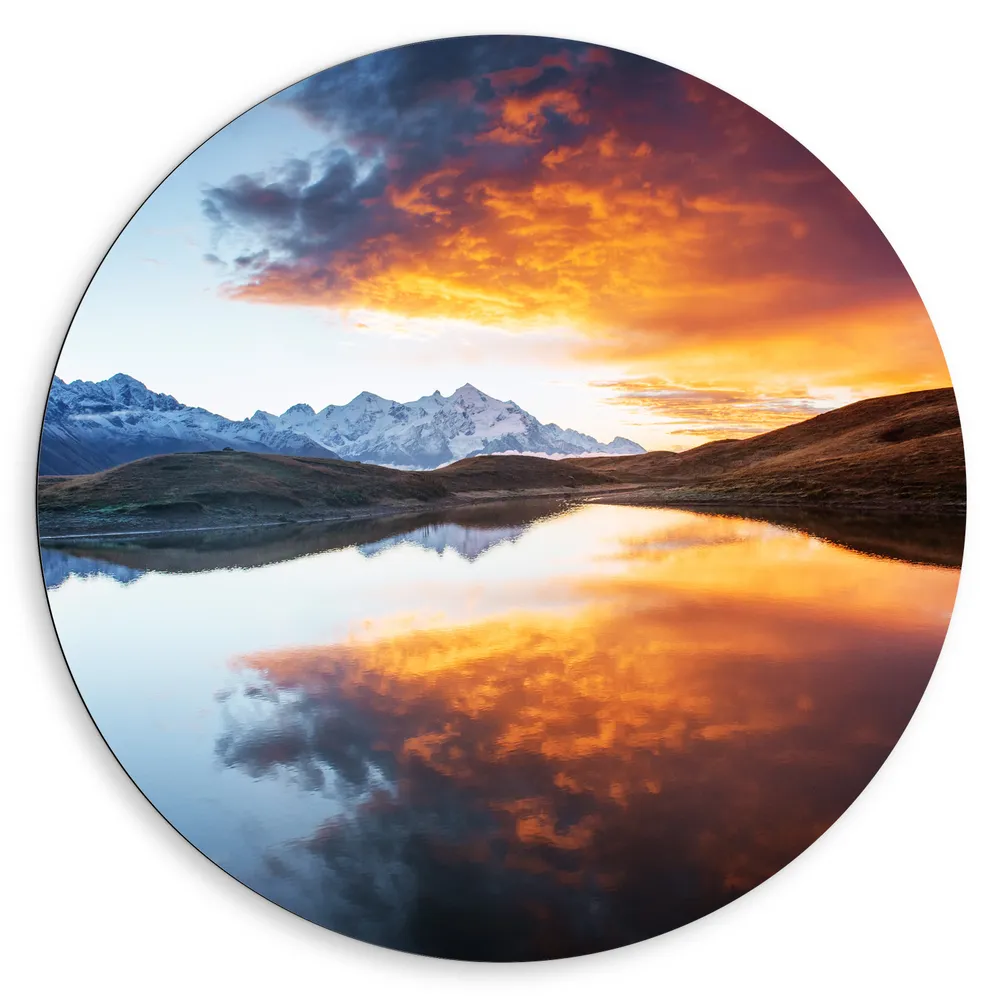 Dibond Muurcirkel - Weerspiegeling van Oranje Gloed op Wolken in Water bij Bergen