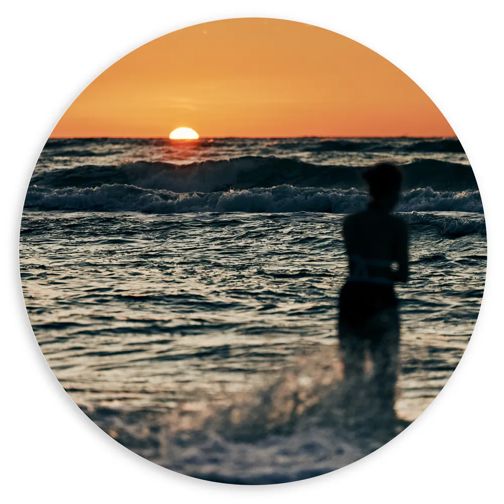 Dibond Muurcirkel - Silhouet van Vrouw in de Wilde Zee tijdens Zonsopkomst