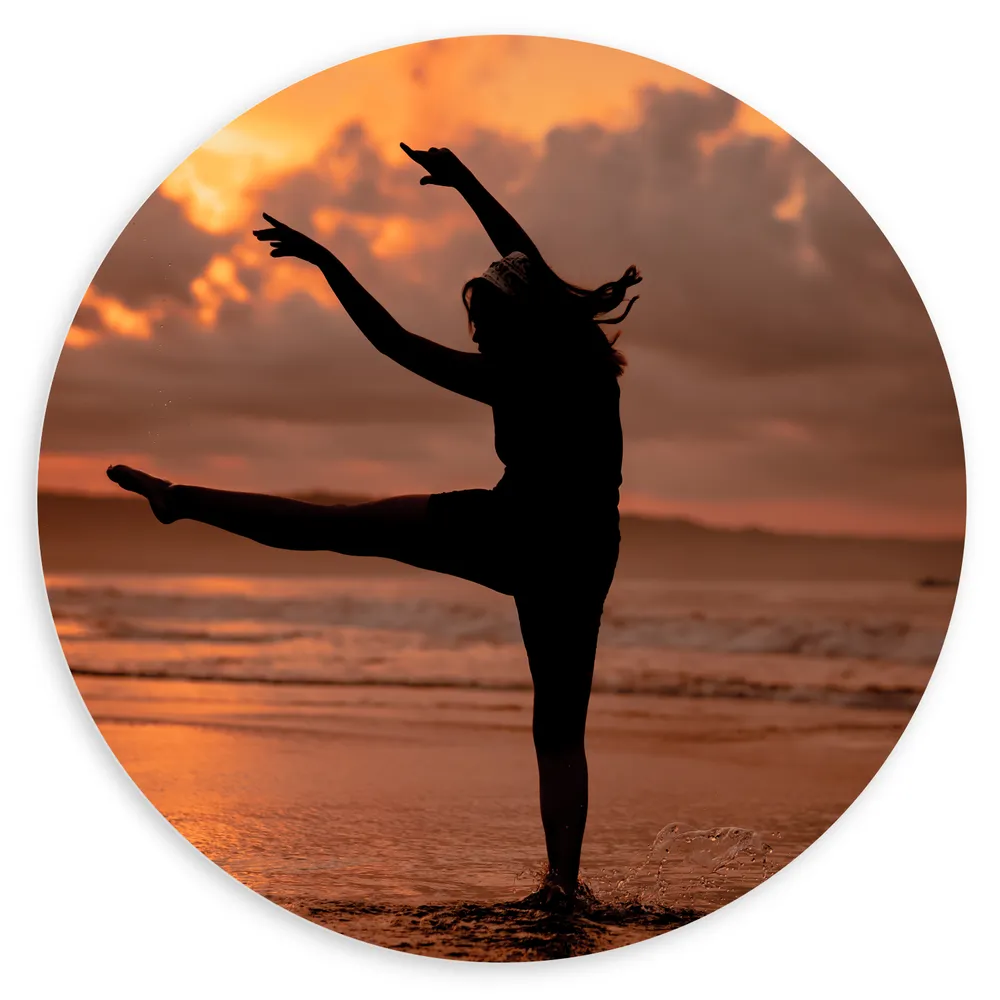 Dibond Muurcirkel - Silhouet van Ballet Danseres aan de Kust tijdens Zonsondergang