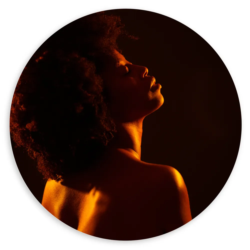Dibond Muurcirkel - Vrouw met Afro en Oranje Gloed op Lichaam