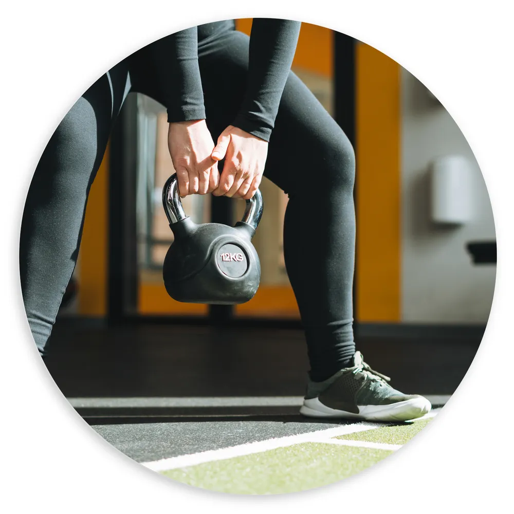Dibond Muurcirkel - Vrouw aan het Trainen met Kettlebell