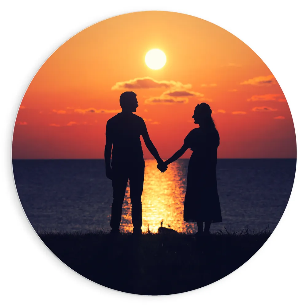 Dibond Muurcirkel - Silhouet van Koppel Hand in Hand bij de Zee tijdens Zonsondergang
