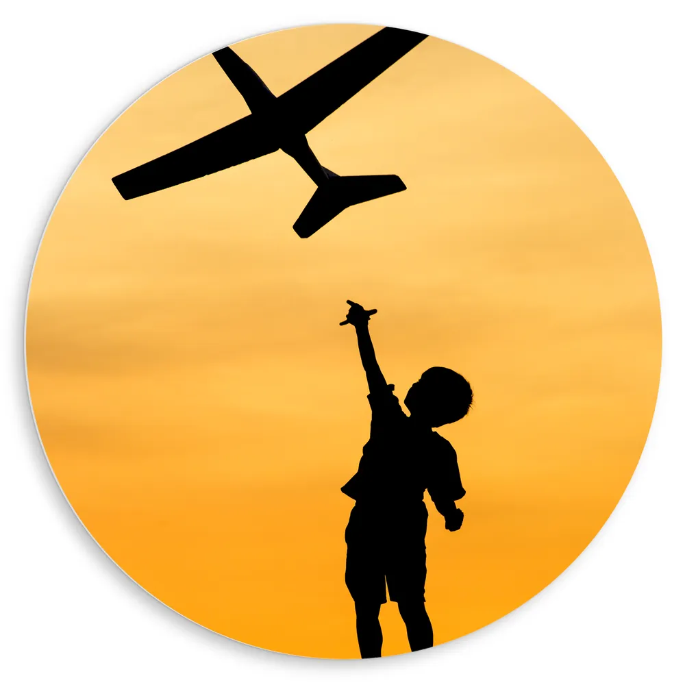 Dibond Muurcirkel - Silhouet van Peuter die Vliegtuig Gooit bij Gele Horizon