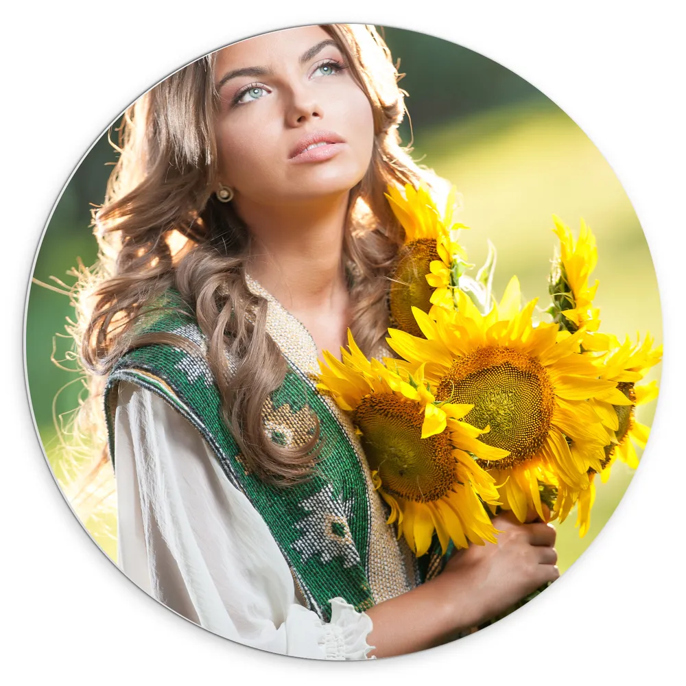 Dibond Muurcirkel - Vrouw met Felblauwe Ogen met Zonnebloemen in de Hand in het Veld