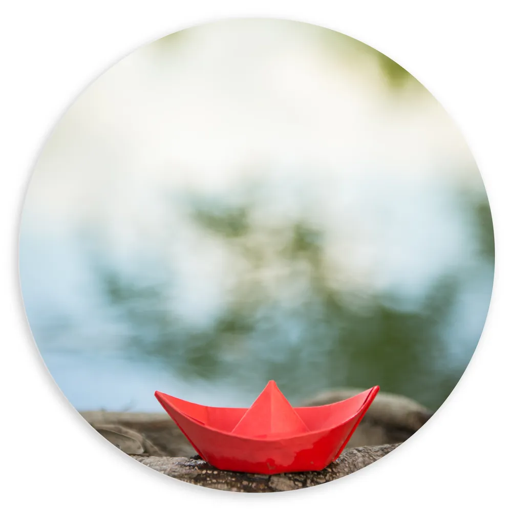Dibond Muurcirkel - Rood Origami Bootje op Boomstam langs Water