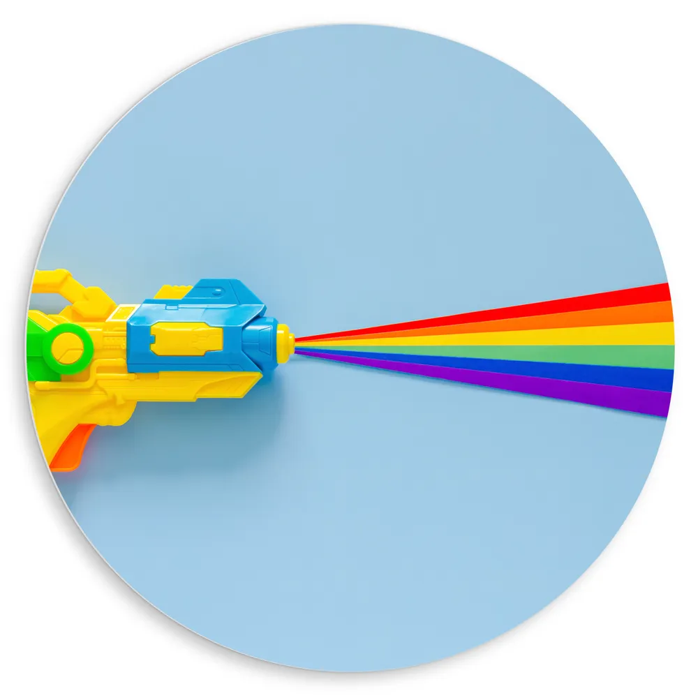 Dibond Muurcirkel - Waterpistool met Regenboogkleurig Water tegen Lichtblauwe Achtergrond
