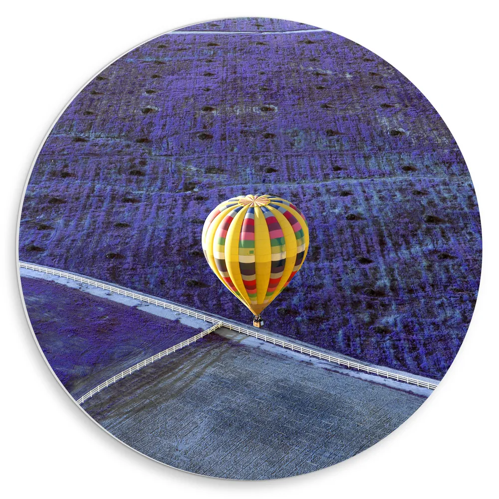 Dibond Muurcirkel - Gele Luchtballon met Kleurrijke Strepen boven Paarse Bloemenvelden