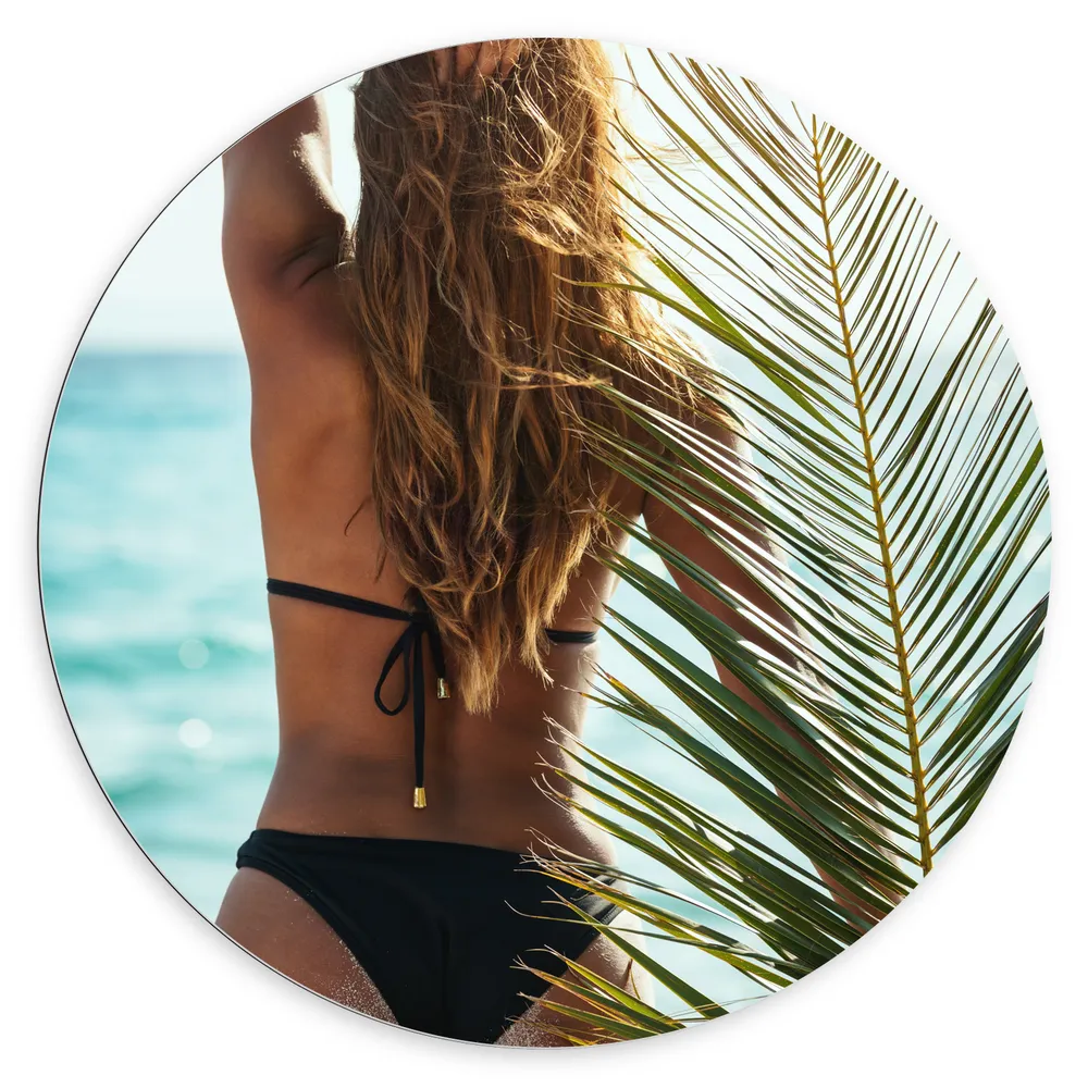 Dibond Muurcirkel - Achteraanzicht van Vrouw in Bikini aan Zee met Palmblad