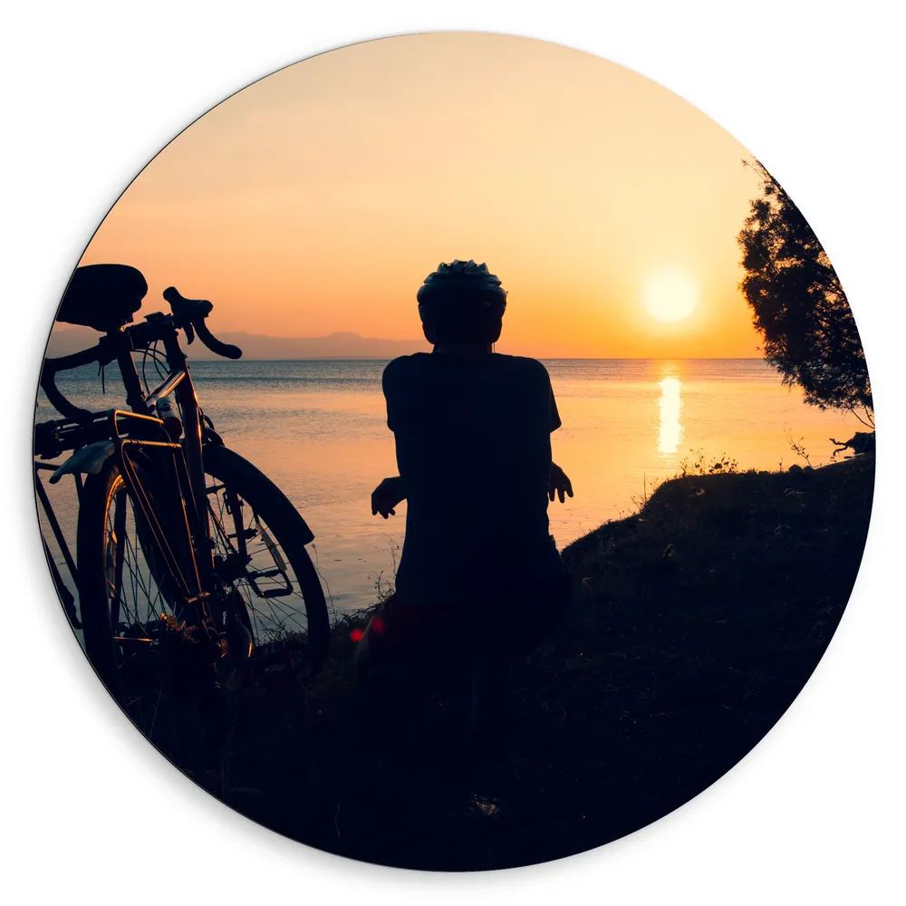 Dibond Muurcirkel - Silhouet van Rustende Fietser met Fiets aan het Water bij Zonsondergang