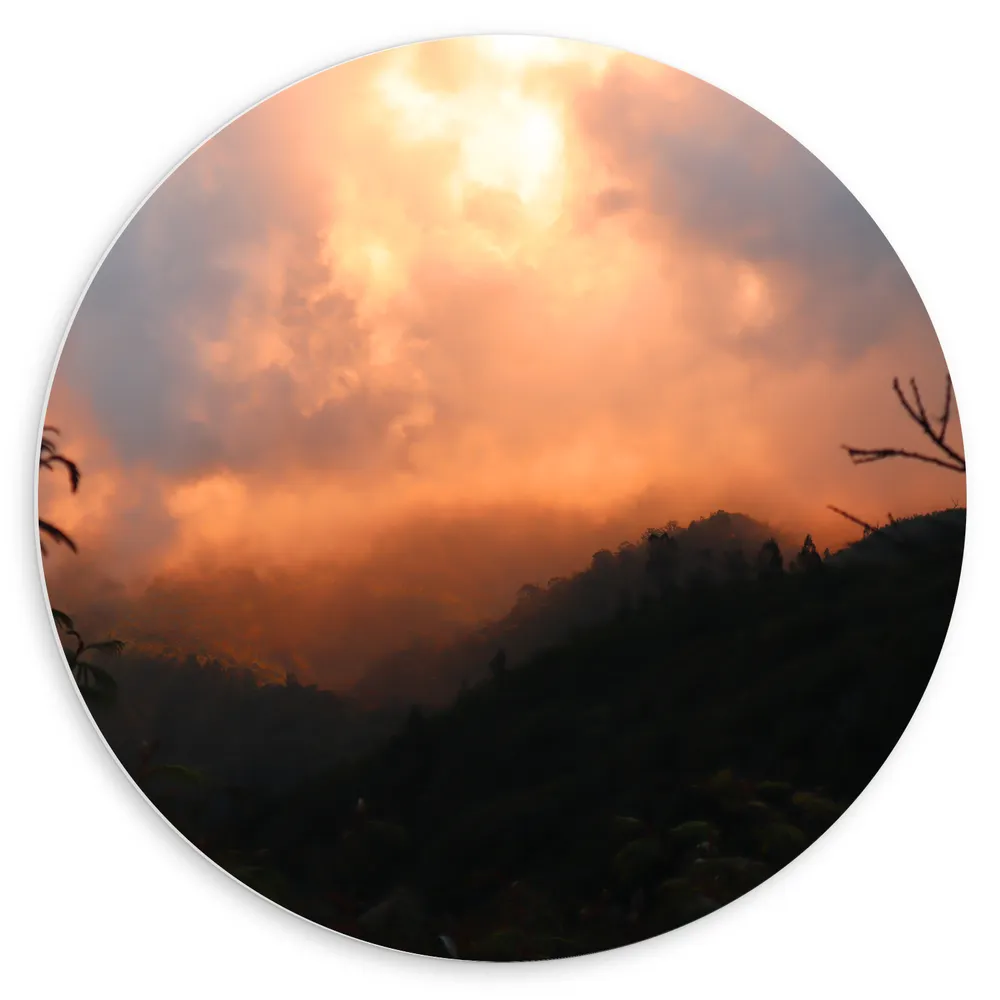 Dibond Muurcirkel - Zon achter Dicht Wolkenveld in Berglandschap