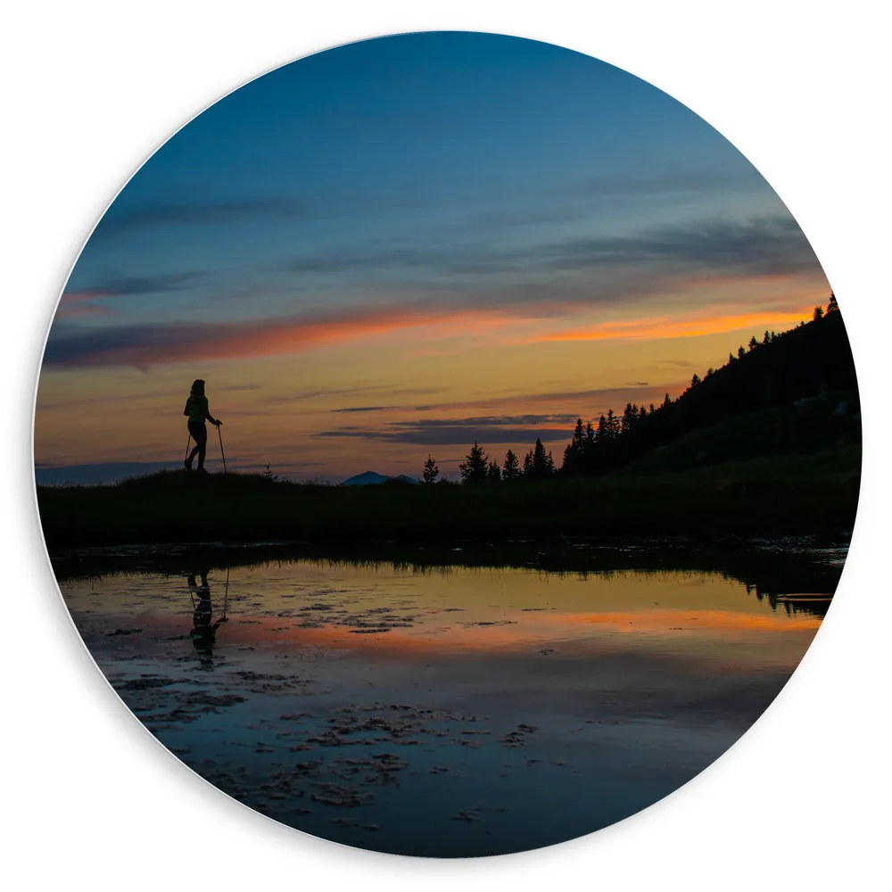 Dibond Muurcirkel - Silhouet van Wandelenaar langs Meer in Berggebied tijdens de Avond